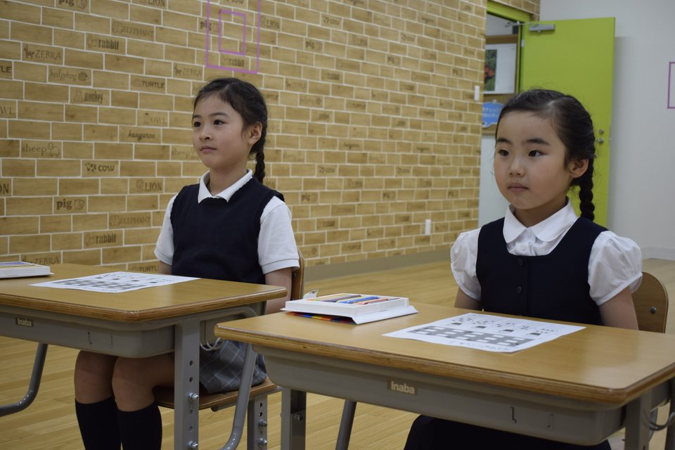 教室で着席して話を聞く子どもたち
